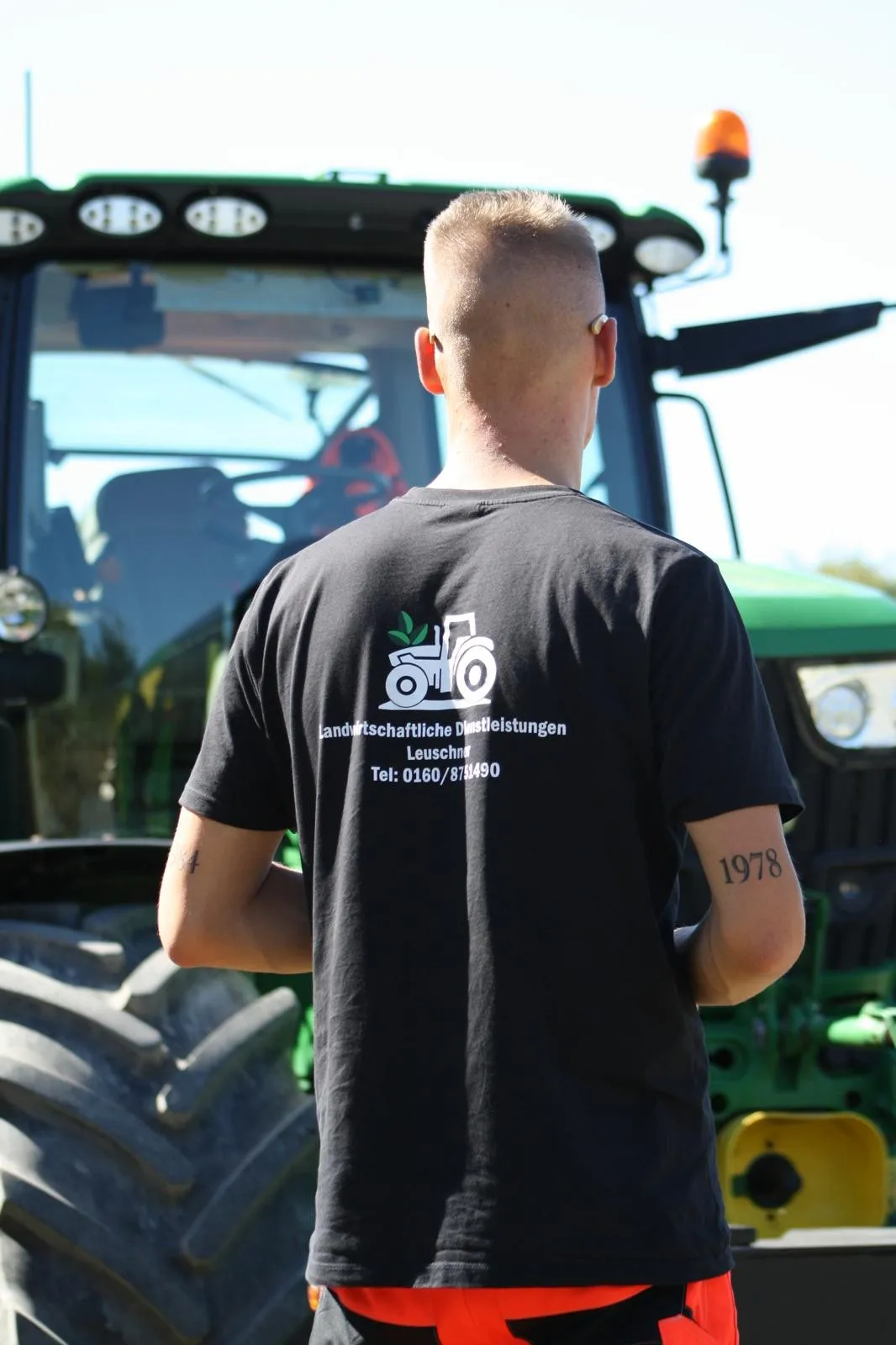 Lukas Leuschner in Arbeitskleidung mit Firmenlogo